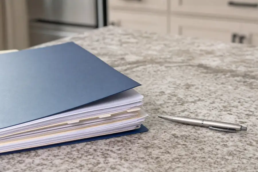 Of an insurance policy folder and pen on a kitchen counter