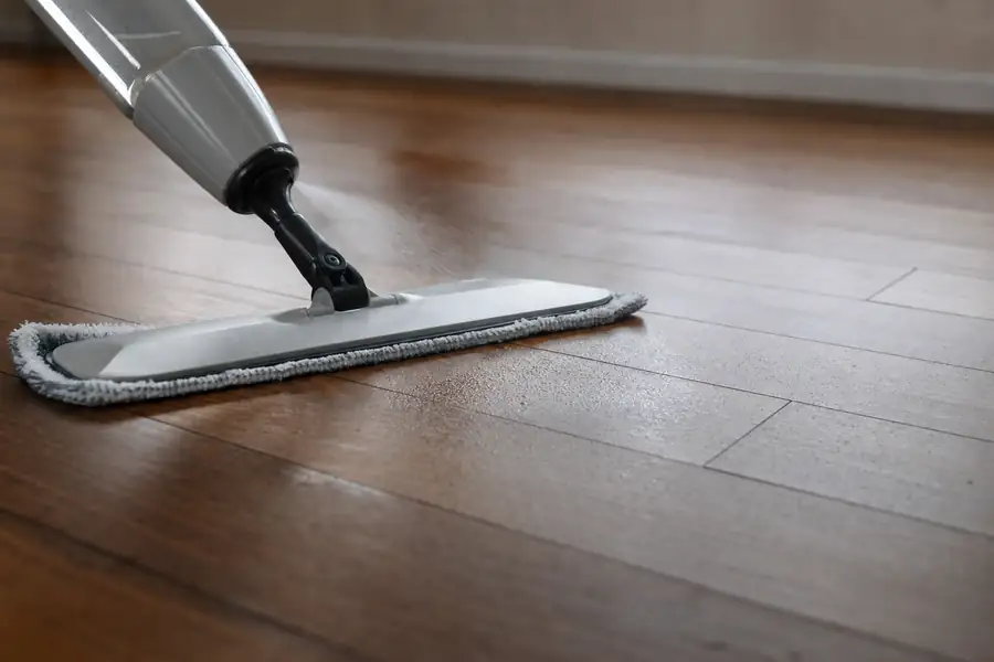 Of a spray mop applying a fine mist to hardwood planks