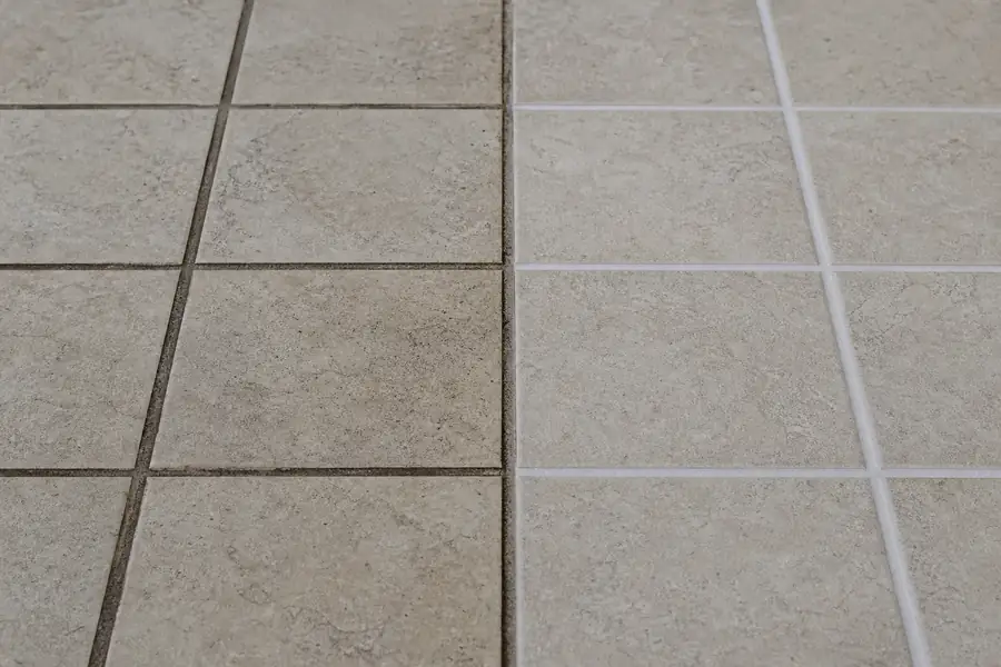Side-by-side tile floor showing stained unsealed grout next to clean sealed grout