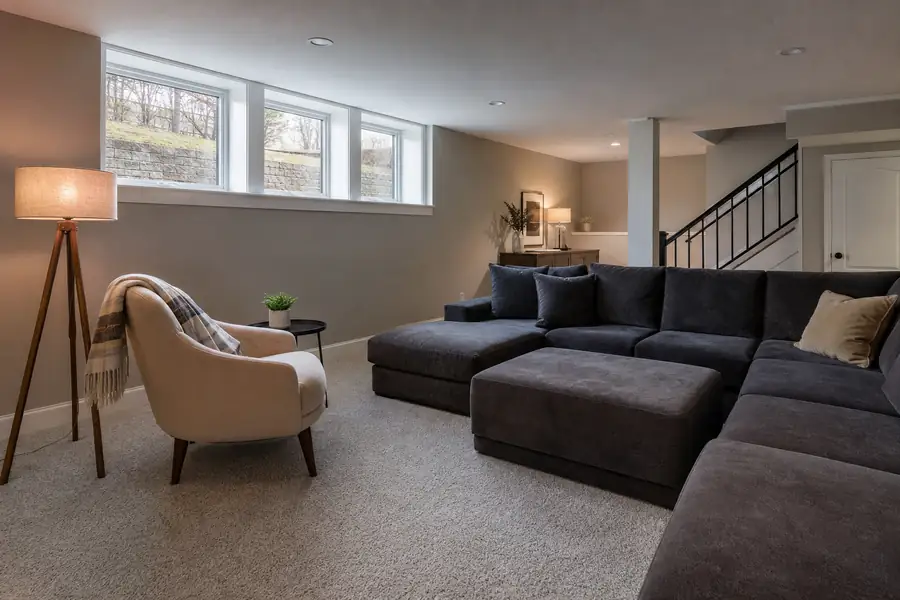 Modern basement family room with light Berber carpet and a reading chair